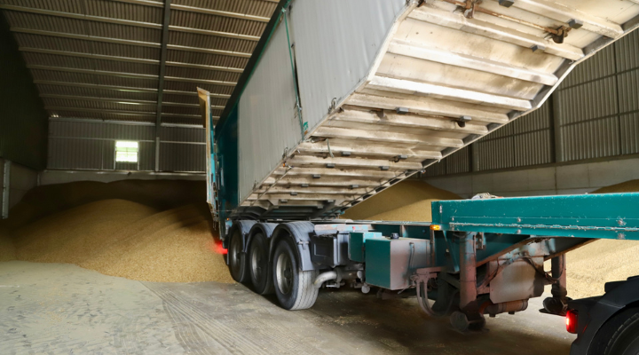 a lorry is tipping pellets onto the floor of a barn